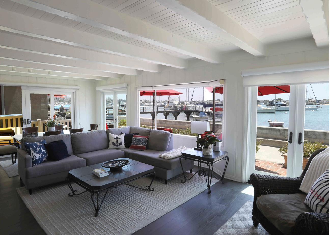 Living room with white beamed ceiling opening onto the harbor
